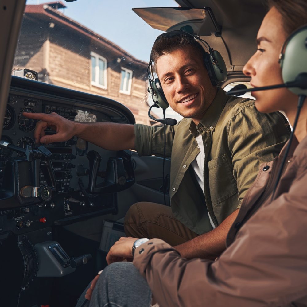 cheerful-young-man-giving-flight-lesson-to-woman.jpg